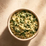Close-up of creamy spinach orzo with parmesan in a bright setting