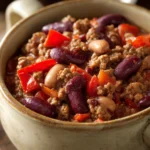 Close-up of Chili Con Carne with beans and spices in a warm, inviting setting.