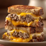 Close-up of a grilled cheese patty melt with melted cheese and crispy bread.