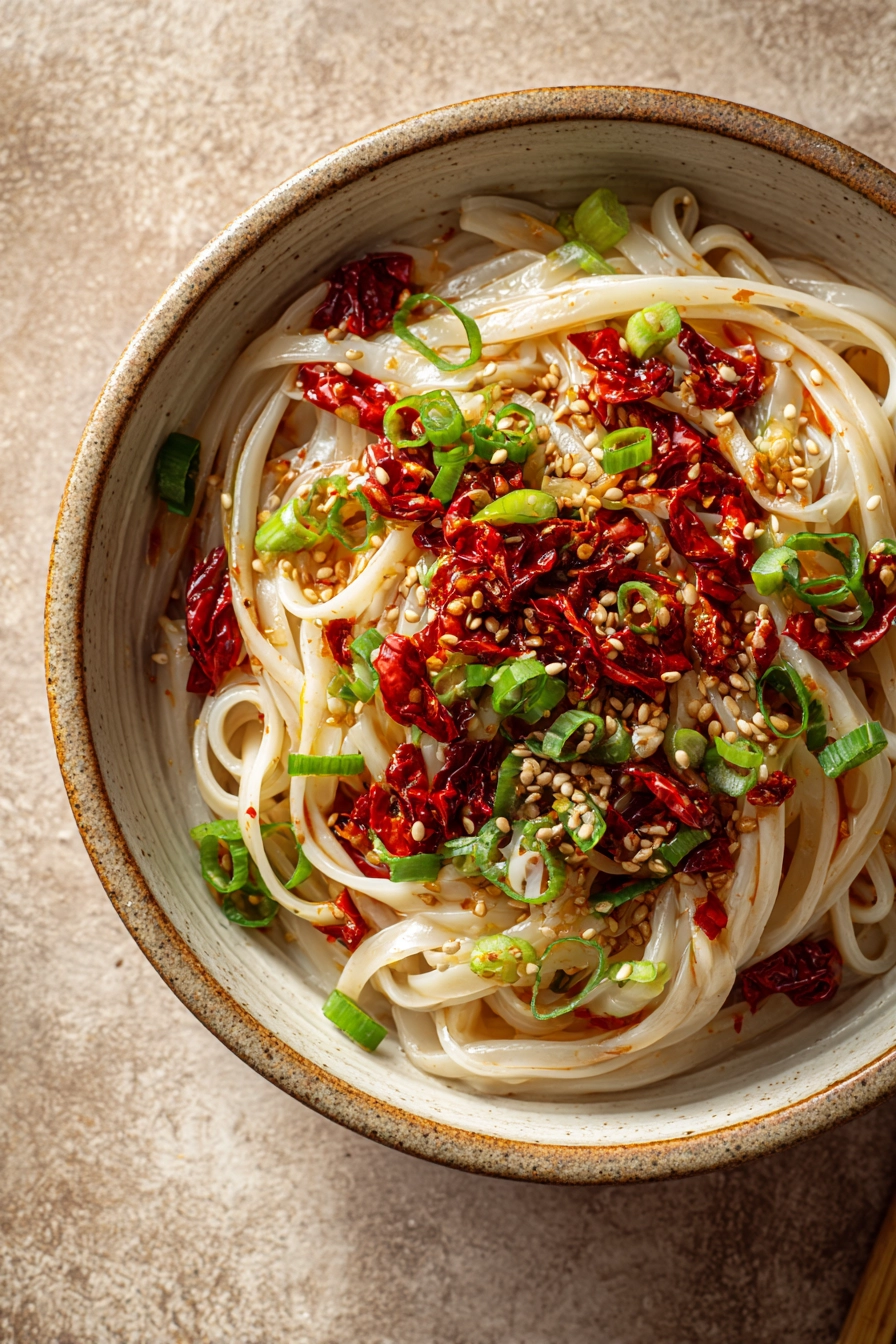 Close-up of spicy noodles with vibrant colors and minimal background